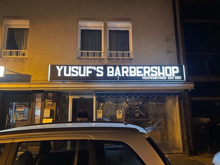 Beleuchtete Profilbuchstaben an der Fassade von Yusuf's Barbershop